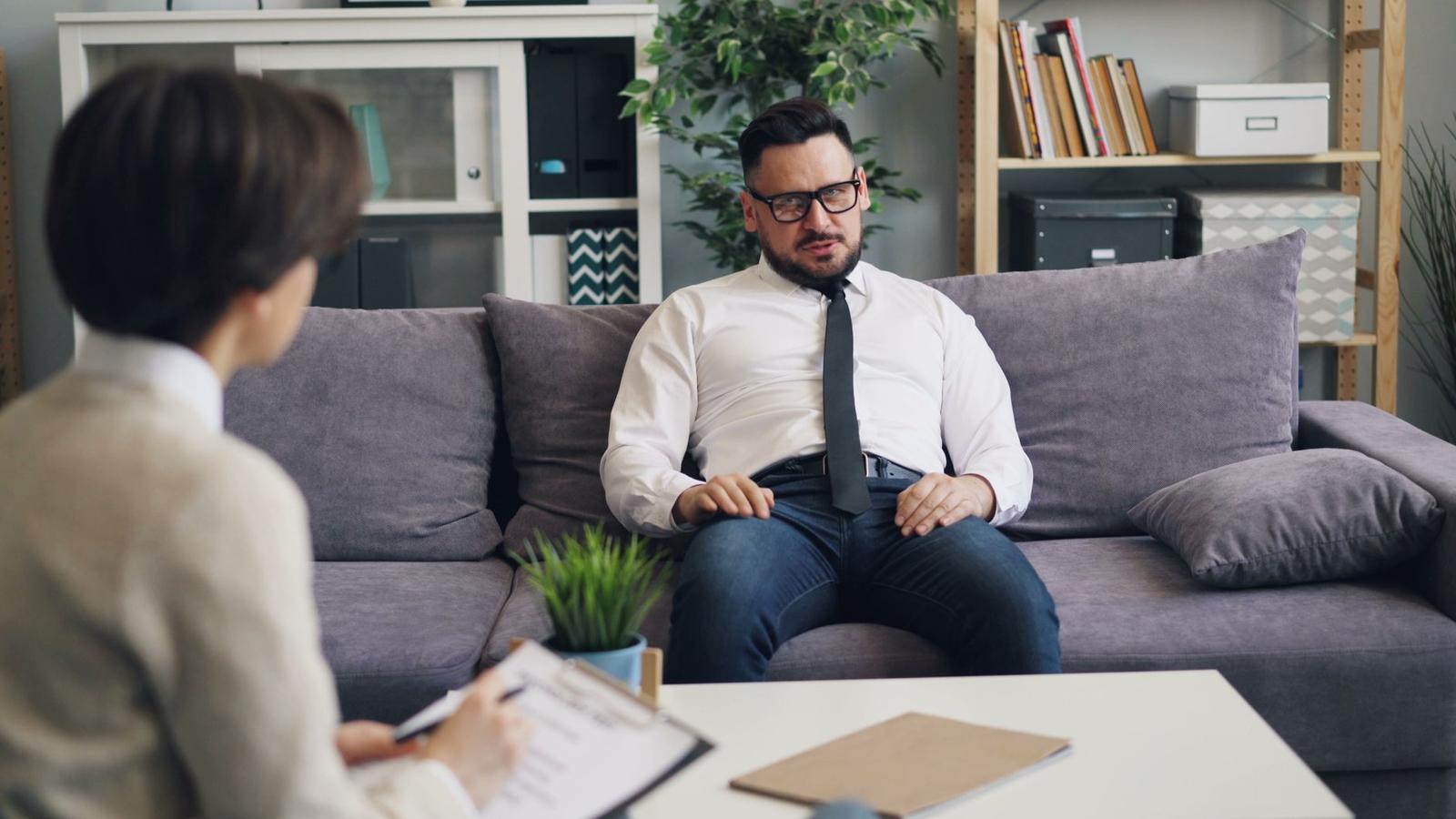 Crop Frustrated Black Man Holding Head in Hands during Psychotherapy